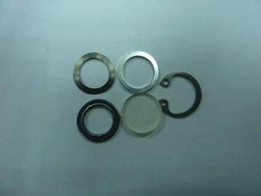Fünf runde Metallteile, darunter ein transparentes, zum Einsatz in technischen Anwendungen, unter anderem von der Marke Remeha.